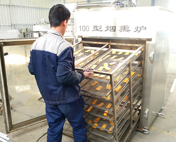 将铺好豆干的推车推入烟熏炉中